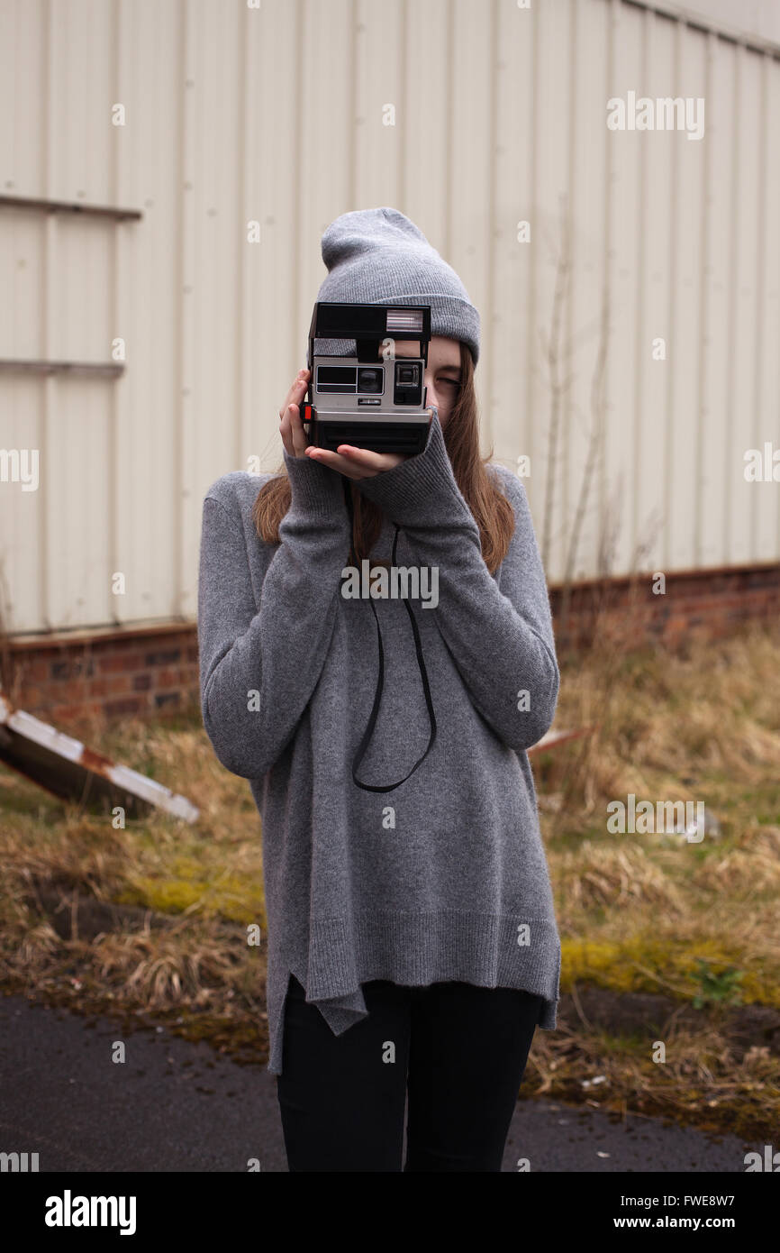 Teenager-Mädchen Fotos mit einer Polaroid-Kamera in einem städtischen Umfeld zu reden Stockfoto