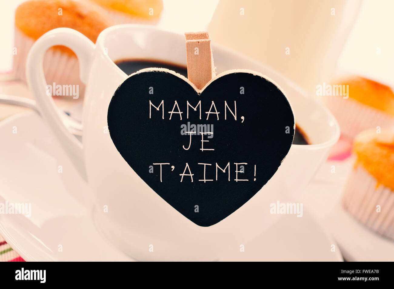 der Satz Maman Je t Aime, ich liebe Sie Mama geschrieben, dass in einer Tasse Kaffee, mit einigen französischen in eine Herzform Tafel platziert Stockfoto