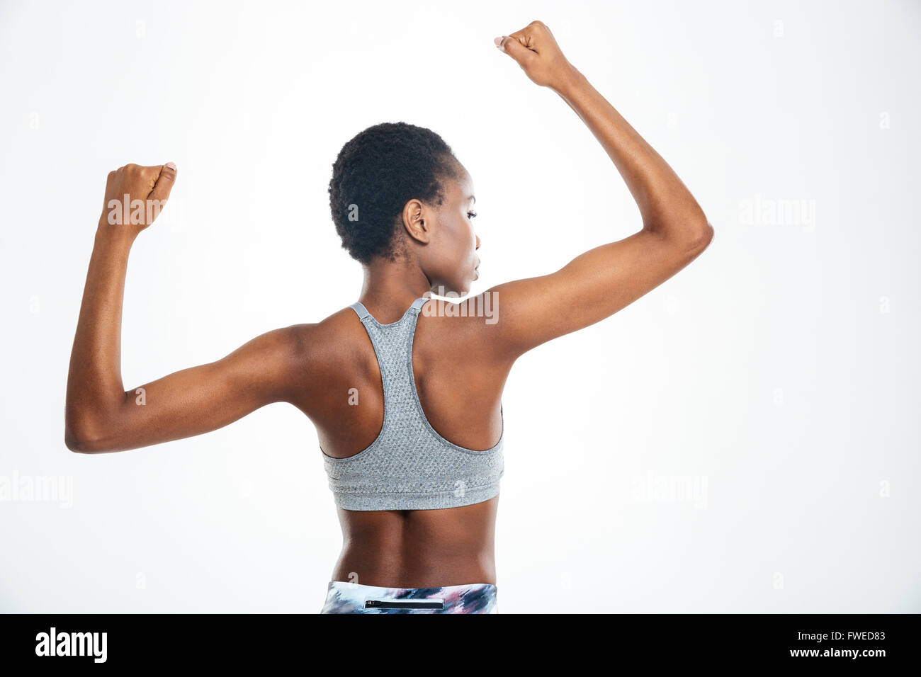 Ansicht-Porträt von Afro-Amerikanerin zeigt ihren Bizeps isoliert auf einem Hintergrund zurück Stockfoto