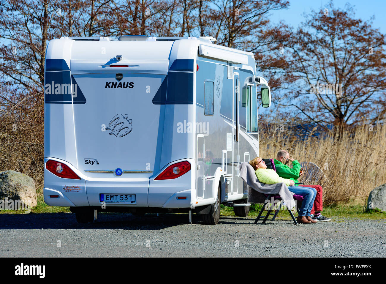 Kivik, Schweden - 1. April 2016: Zwei Personen sitzen in der Sonne draußen ein 2014 Fiat Knaus K250 Aalen. Mann sucht bei mobile Stockfoto