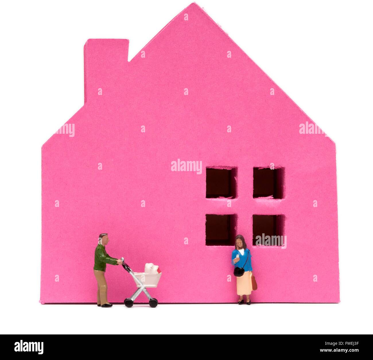 Ein Miniatur-paar vor einem rosa Haus erste Zeit Buyer-Konzept. Stockfoto