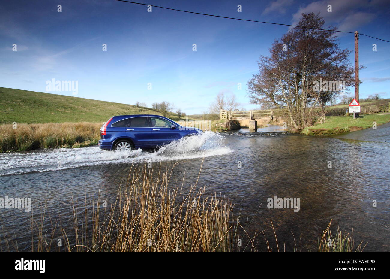 Ein Fahrzeug fährt durchs Wasser bei Tissington Ford in der Nähe von Tissington Dorf, Peak District National Park, Derbyshire England UK Stockfoto