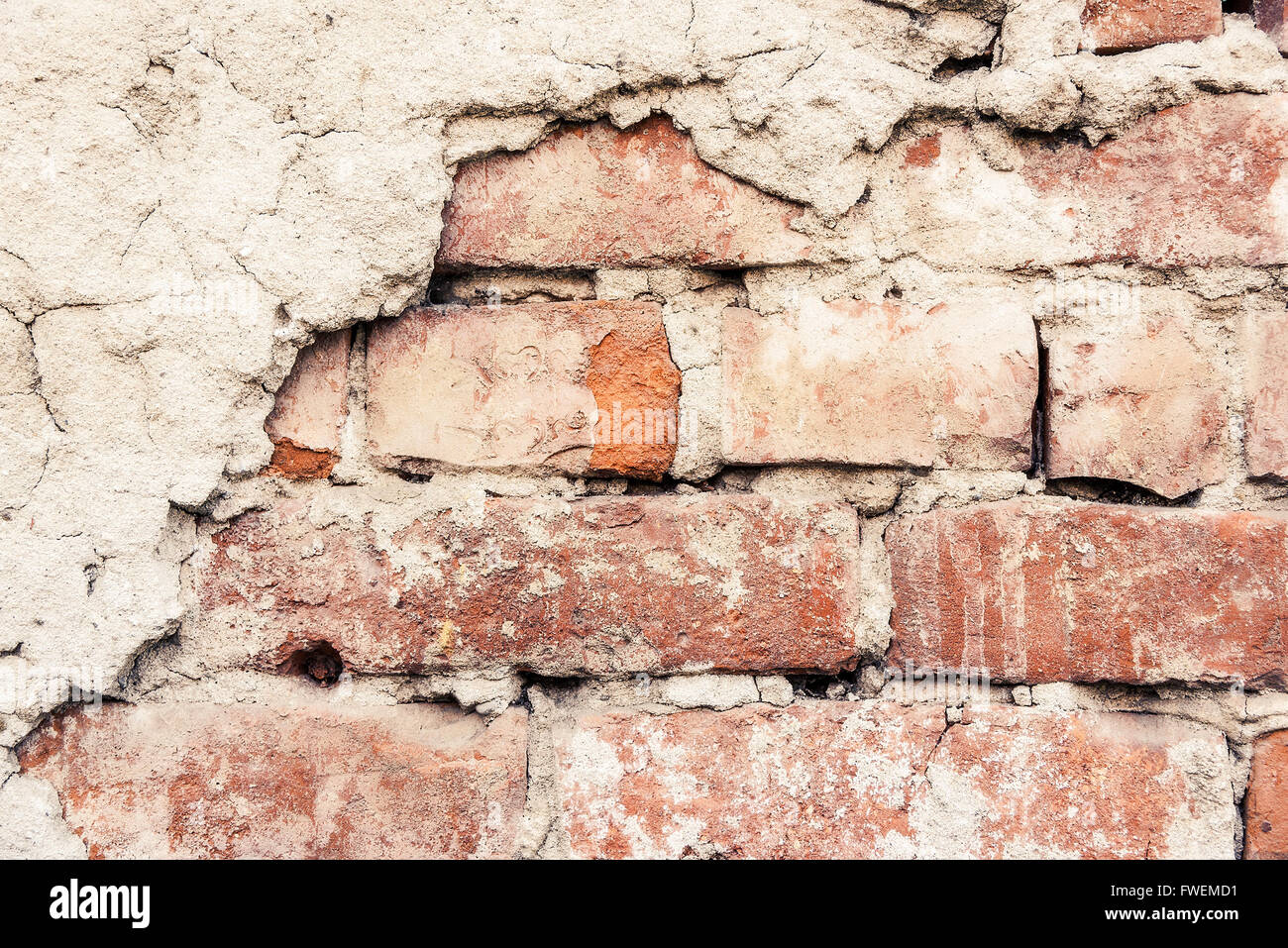 Alten verwitterten Ziegel Wand Fragment mit Stücken aus Gips. Stockfoto