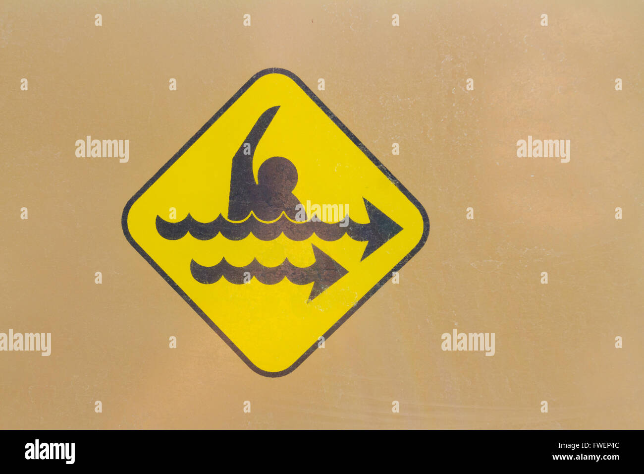 Ein Warnsymbol Zeichen zeigt die Gefahr einer starken Rip-Strömung. Dieses gelbe Gefahr-Zeichen ist universell. Stockfoto