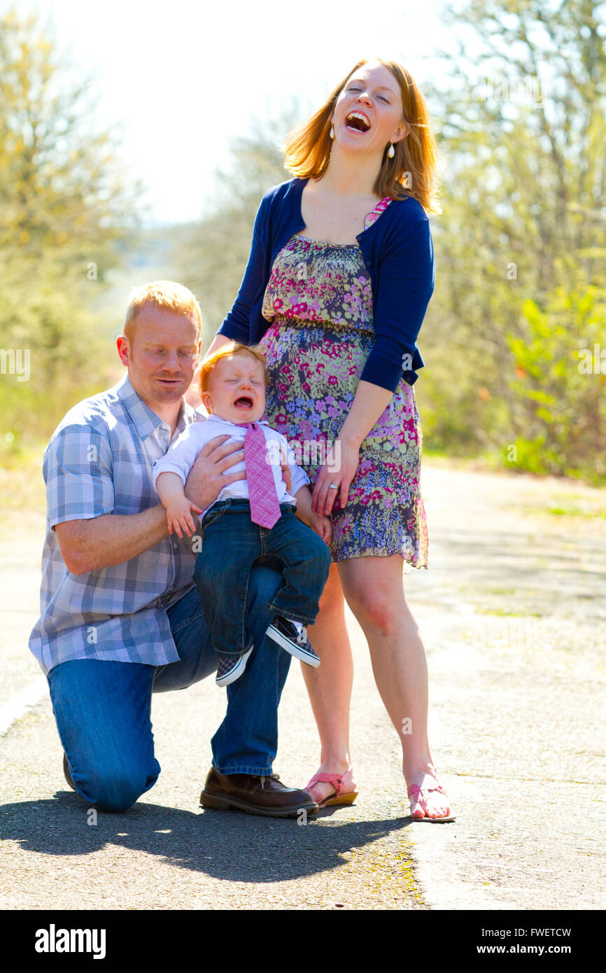 Eine Familie von drei Personen zusammen im Freien tragen schöne Kleider in diesem einfachen Porträt. Stockfoto