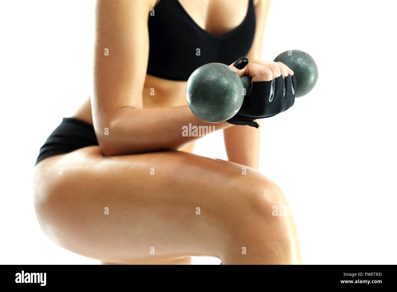 Kleidungsstück Frau Fitness üben. Der Körper einer Frau, körperliche Aktivität. Frau in Sportkleidung wirft die Gewichte. Stockfoto