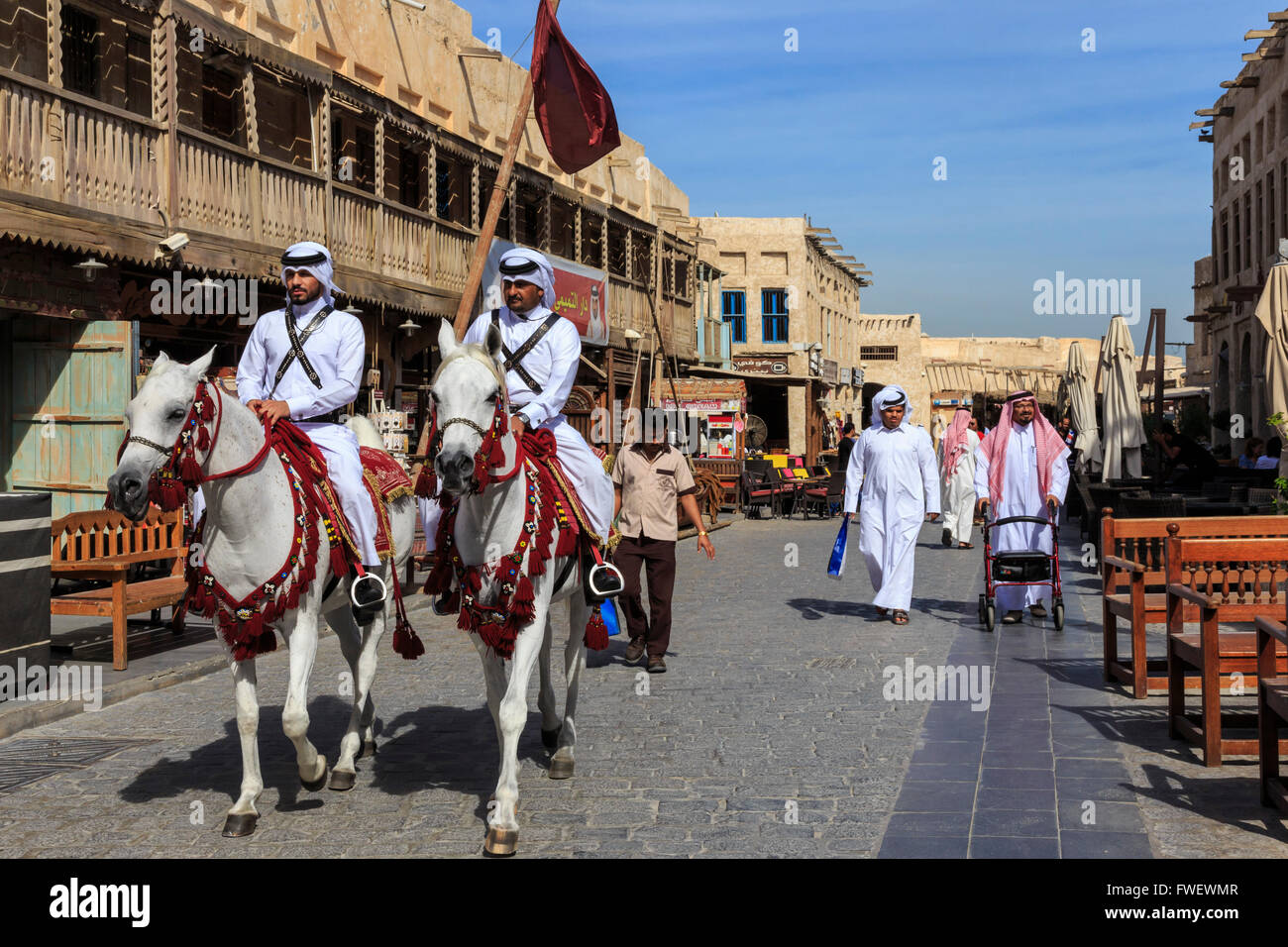 Beschäftigt Straßenszene mit traditionell gekleidet, berittene Polizisten und Shopper, Souq Waqif, Doha, Katar, Nahost Stockfoto