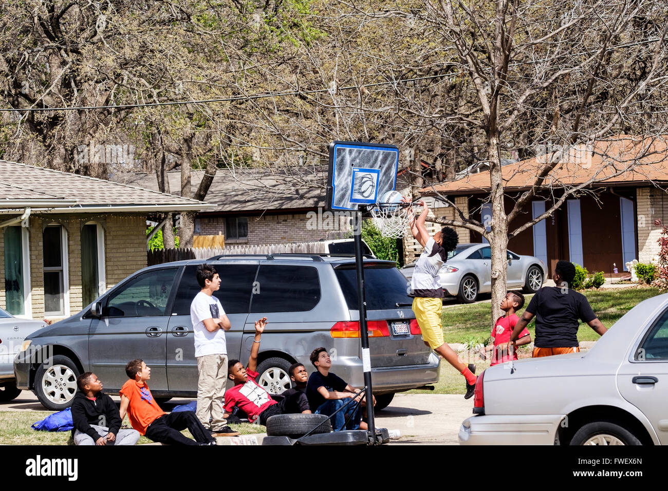 Teen und pre-teen-Boys sammeln und spielen Basketball auf der Straße in Oklahoma City, Oklahoma, USA. Stockfoto