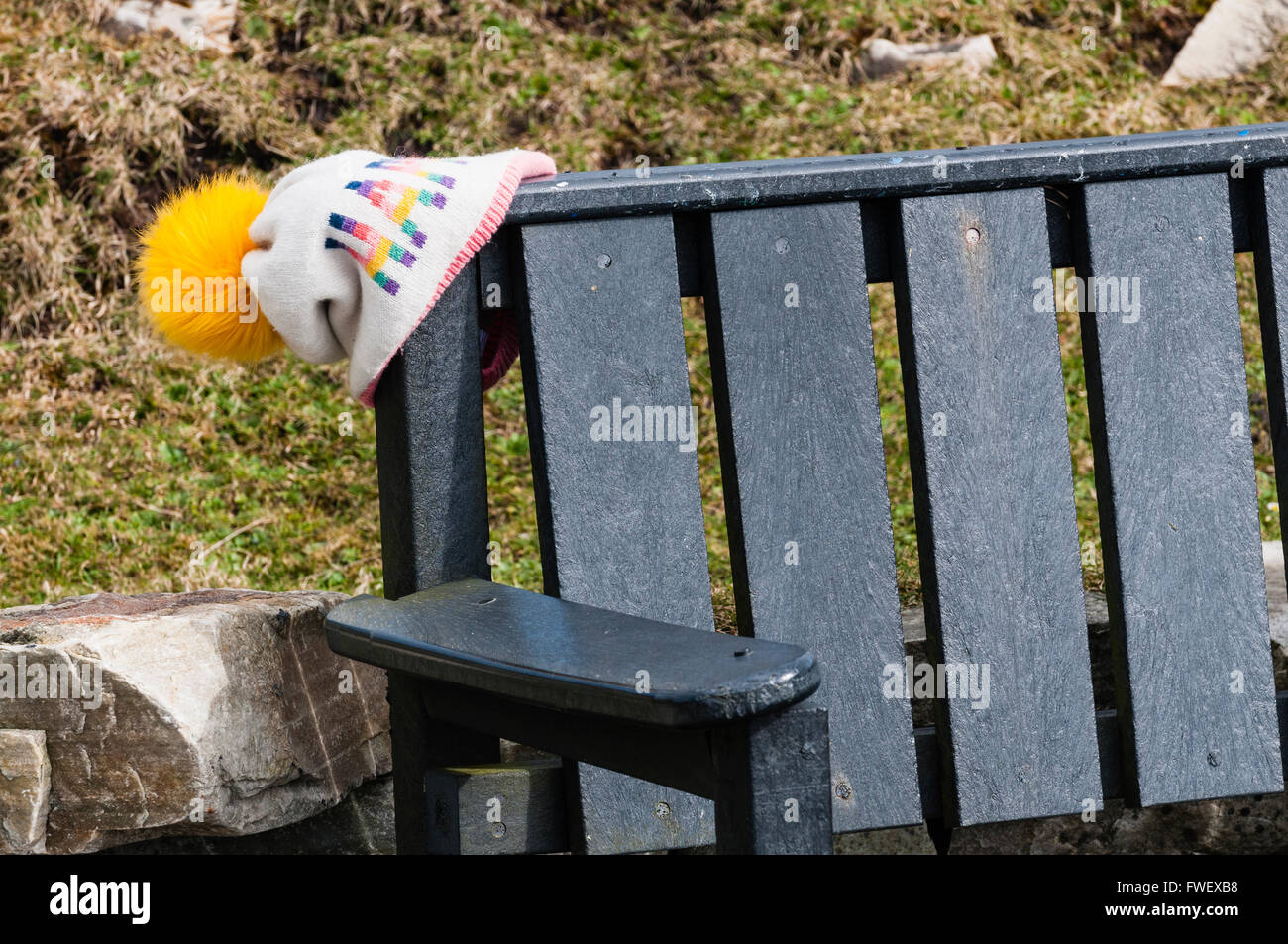Verlorenes Kind Wollmütze links auf einer Parkbank. Stockfoto