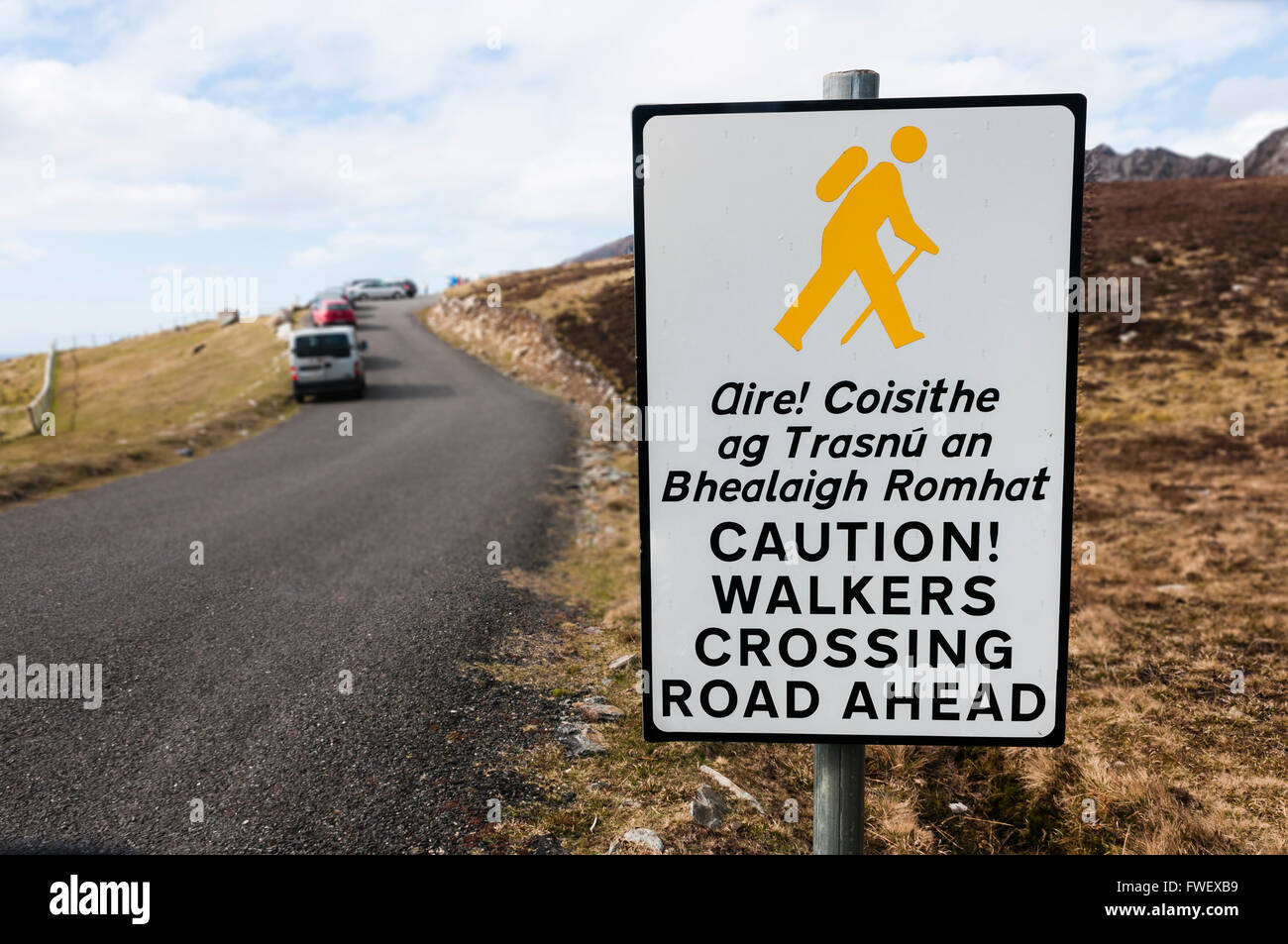 Melden Sie an, Irisch und Englisch, Warnung Fahrer, dass Wanderer die Fahrbahn überqueren. Stockfoto