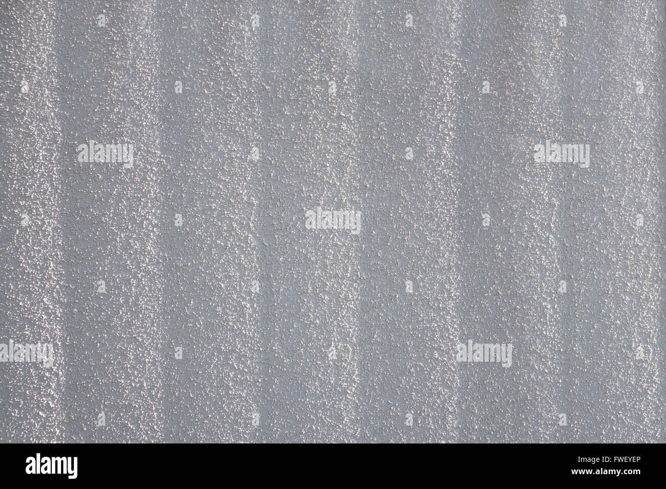 Körnig, leichte graue Putz mit vertikalen Struktur im Sonnenlicht. Genommen in Nahaufnahme. Stockfoto
