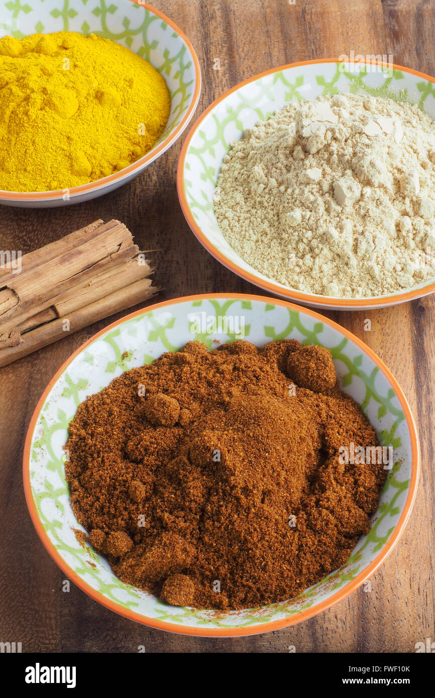 Gemahlene Gewürze in Schalen mit Zimtstangen Stockfoto