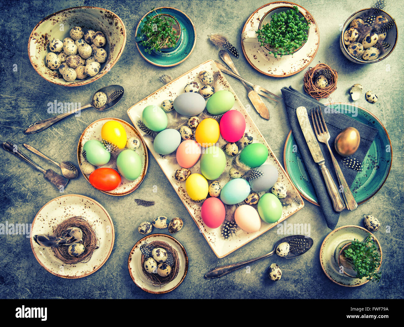 Oster-Deko. Festliche Tischdekoration mit gefärbten Eiern. Vintage-Stil getönten Bild Stockfoto