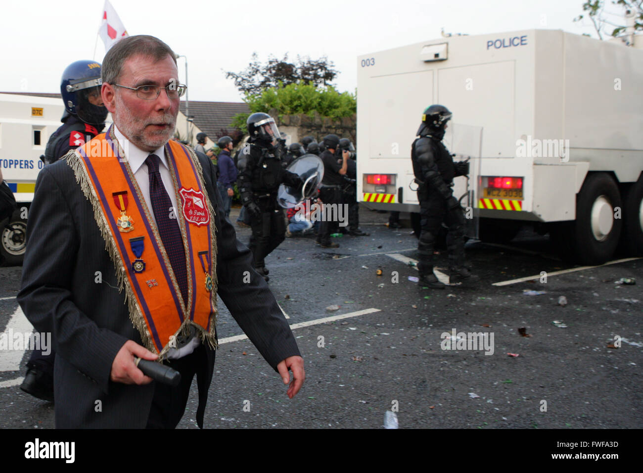 Bewaffnete Polizisten beobachten Loyalisten während der Schwierigkeiten im Norden Belfast nach einem anhaltenden Angriff auf Polizei im Bereich Woodvale Stockfoto