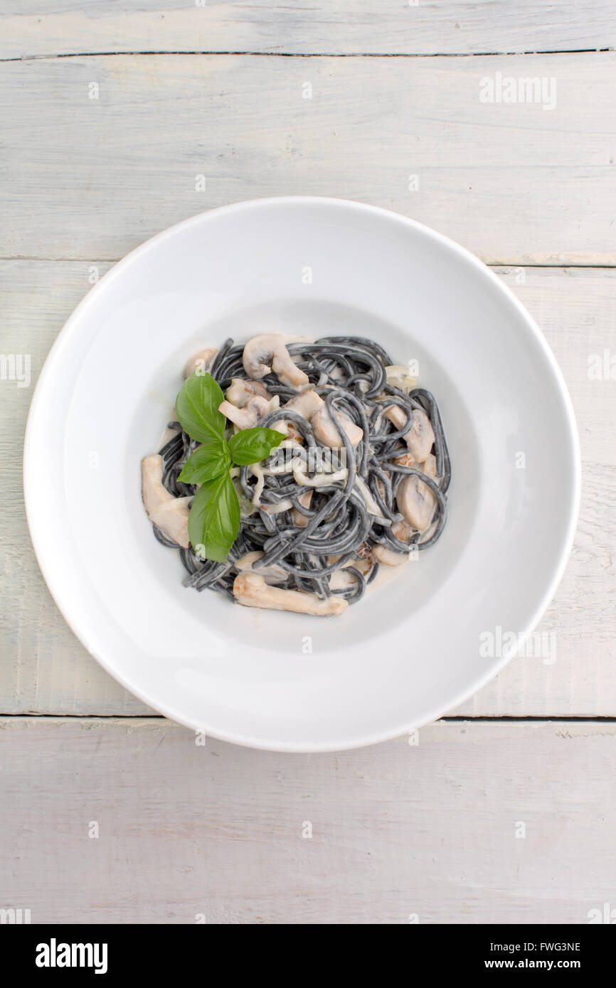 Schwarze Nudeln mit Pilzen und Sahne Stockfoto