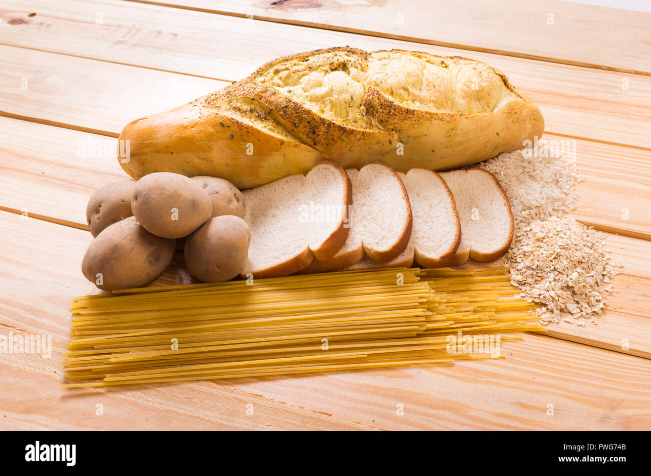 Gruppe der Kohlenhydrate für Ernährung, Brot, Reis, Hafer, Kartoffeln, Nudeln auf Holztisch Stockfoto
