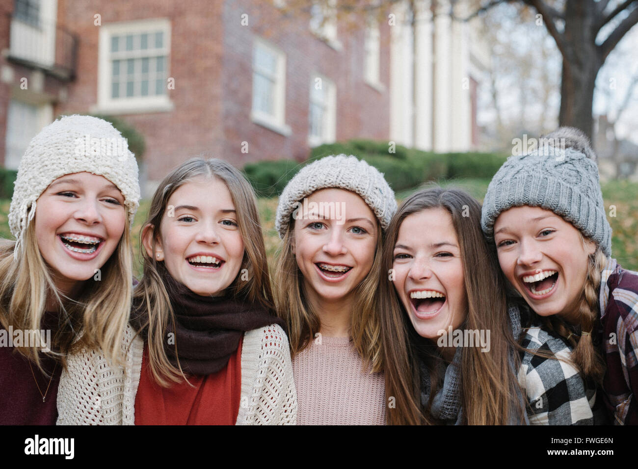 Eine Gruppe von fünf Mädchen im Teenageralter im Freien in Wollmützen und Schals. Stockfoto