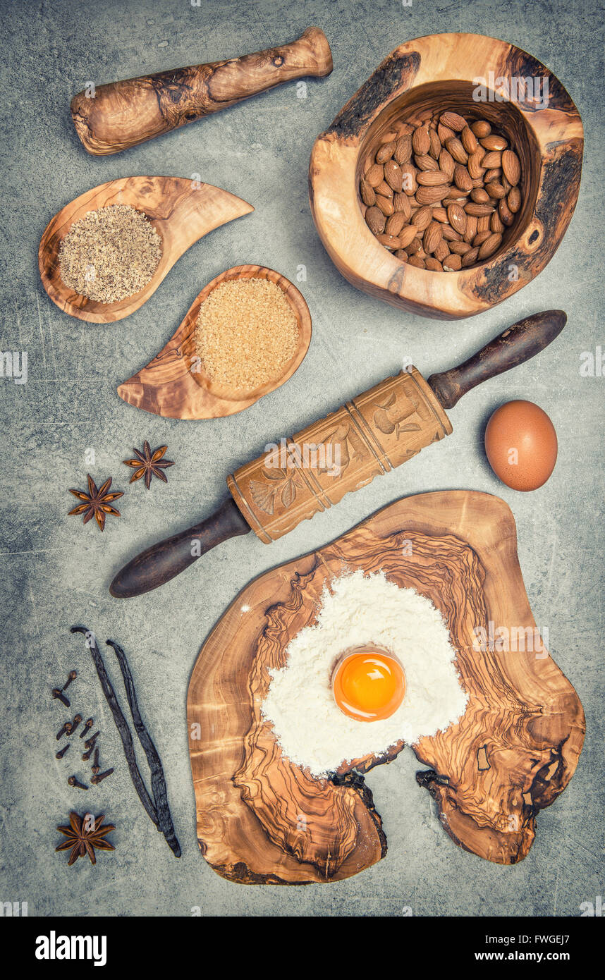 Backen, Utensilien und Zutaten am Küchentisch. Eiern, Mehl, Zucker, Mandeln, Vanille. Vintage-Stil getönten Bild Stockfoto