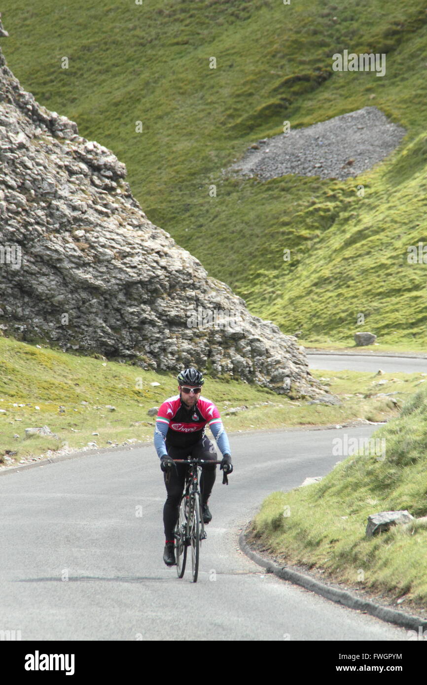 Ein männlicher Radfahrer steigt Winnats Pass, einem steilen Kalkstein Spalt in Castleton, High Peak, Peak District, Derbyshire England UK Stockfoto