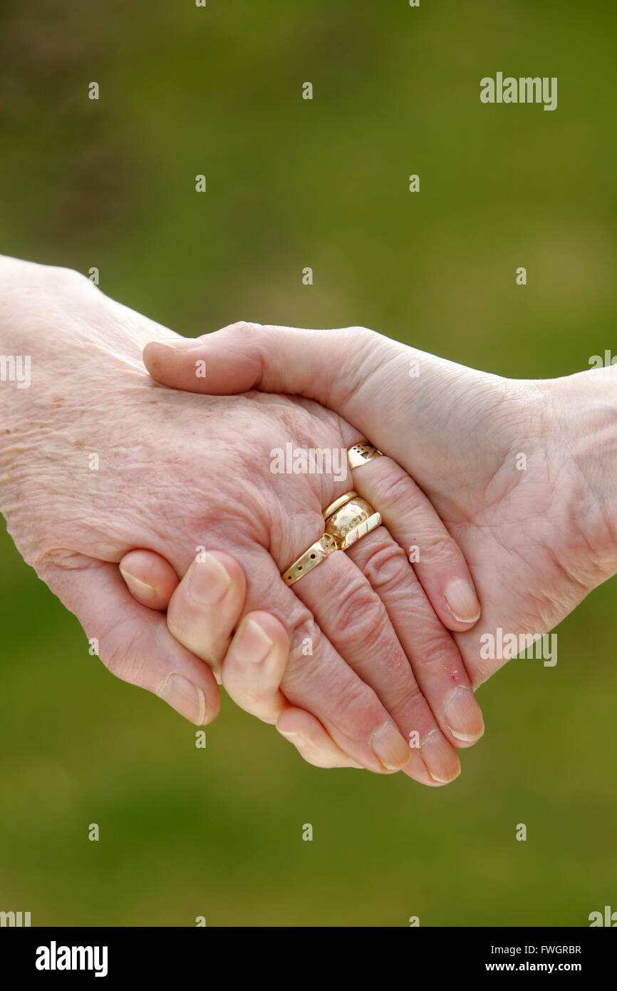 Alte und junge Person Holding Hands Stockfoto