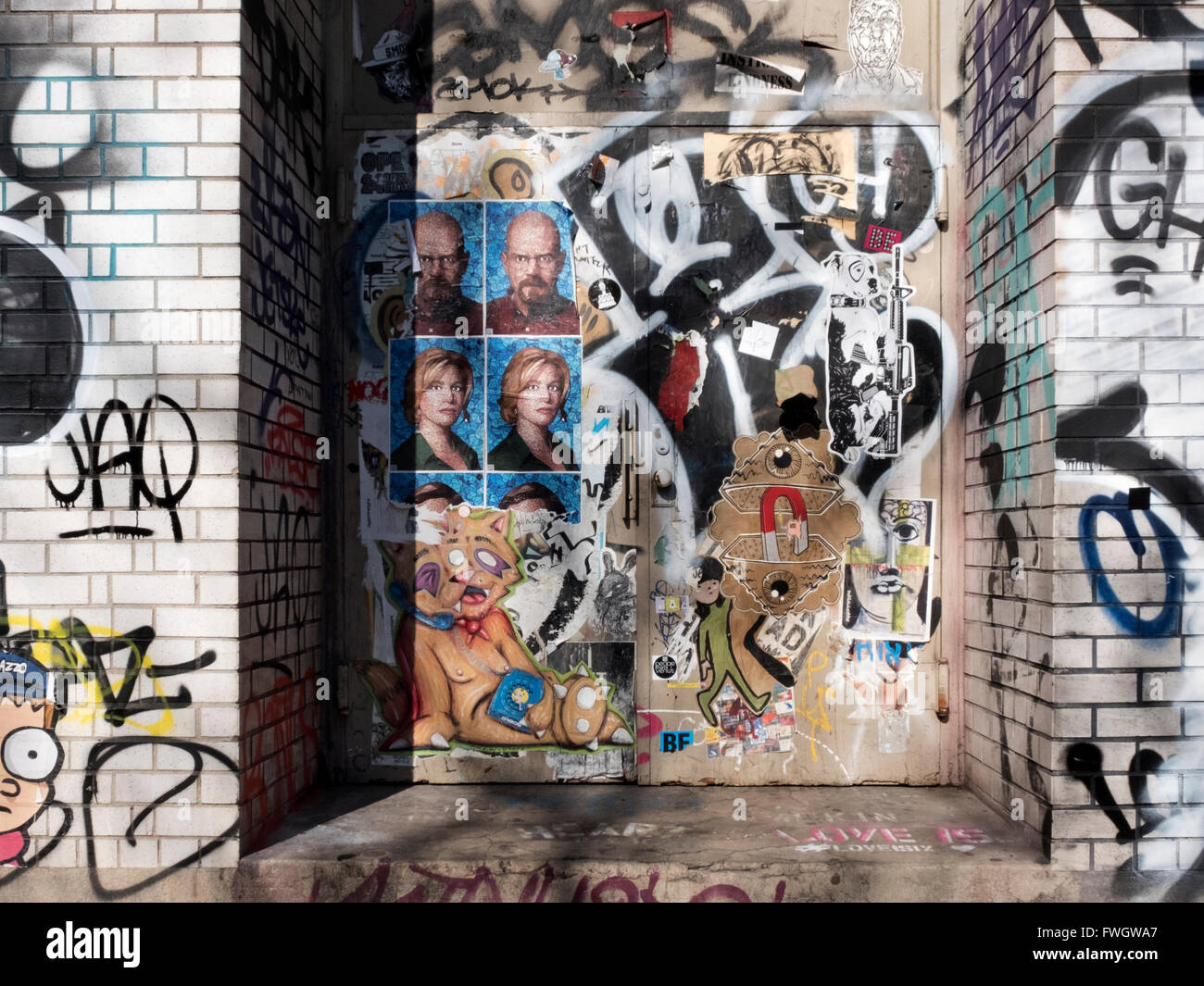 Eine Tür im Abschnitt Nolita von Downtown Manhattan mit zerrissenen Plakate, Graffiti und Taggings. Stockfoto