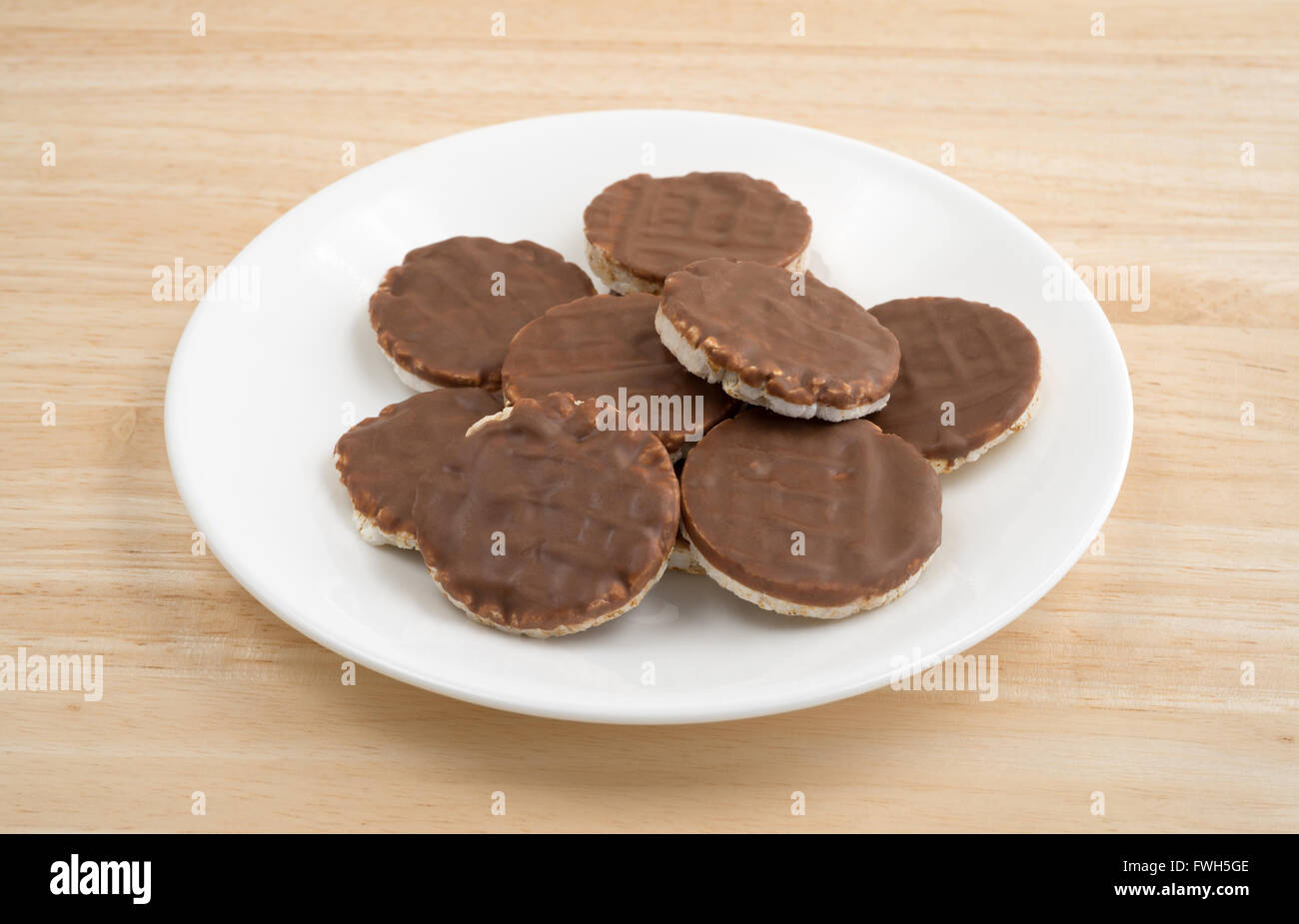 Seitenansicht einer Gruppe von Bio-Reis Kekse mit Milchschokolade Sahnehäubchen auf einer hölzernen Tischplatte. Stockfoto