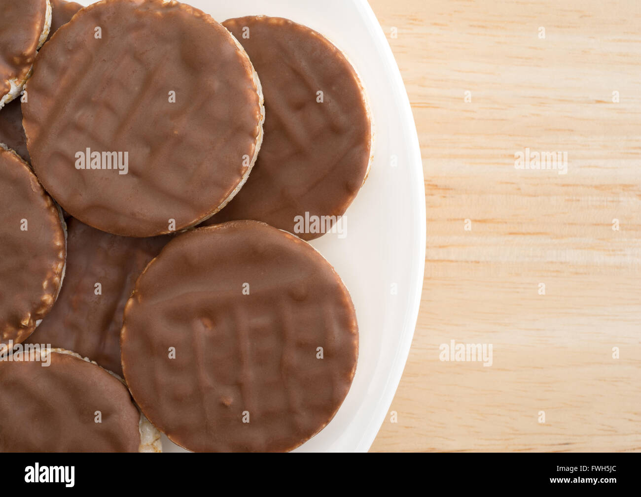 Enge Draufsicht einer Gruppe von Bio-Reis Kekse mit Milchschokolade Sahnehäubchen auf einer hölzernen Tischplatte. Stockfoto
