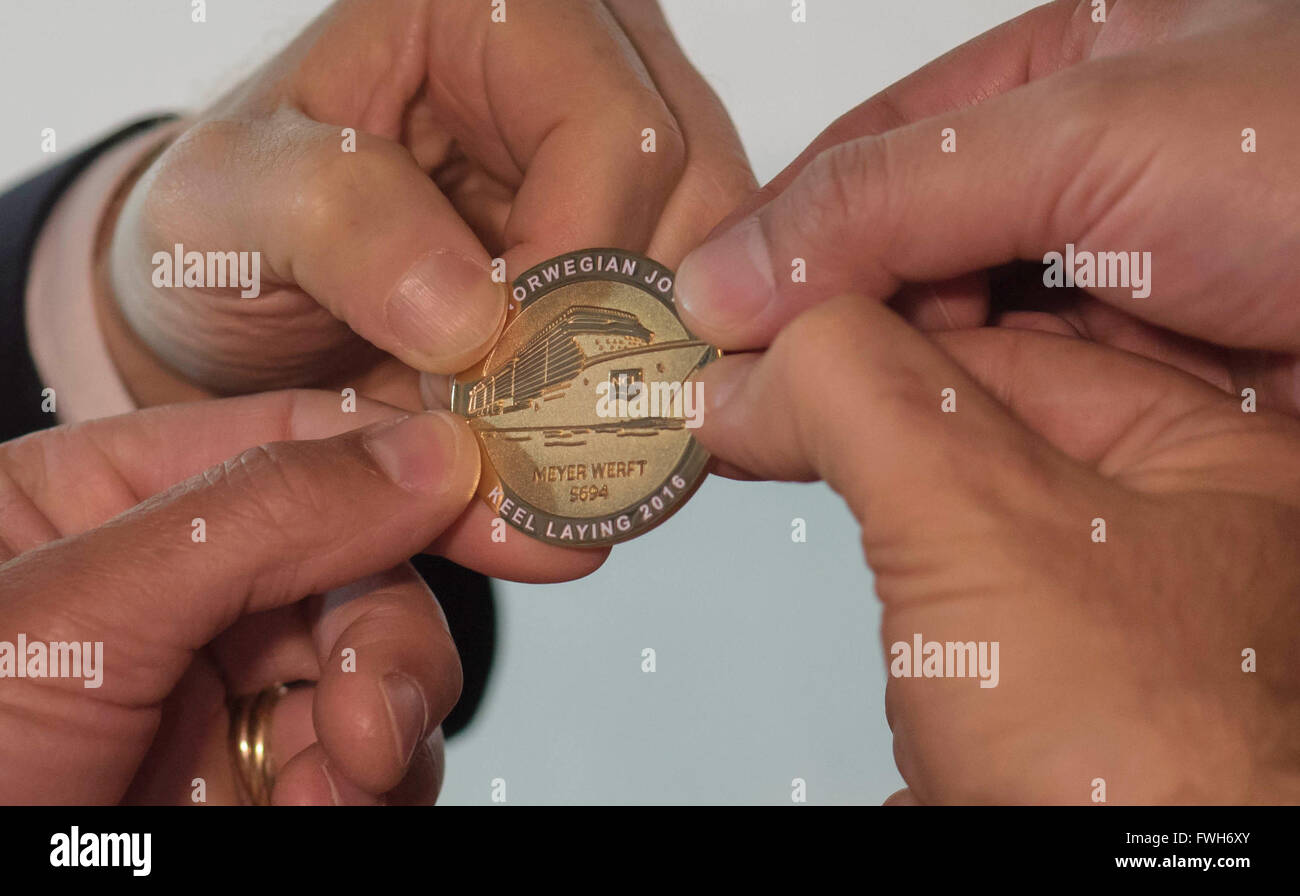 Lambert Kruse (oben links im Uhrzeigersinn), Geschäftsführer der Meyer Werft, David Herrera, general Manager von NCL China, Alex Xiang, Vice President von NCL China und Bernhard Meyer, Geschäftsführer der Meyer Werft, halten eine Gedenkmünze während die Kiellegung des neuen Kreuzfahrtschiffes "Norwegische Freude" in Papenburg, Deutschland, 5. April 2016. U.S. Reederei Norwegian Cruise Line beauftragt hat ihre erste Kreuzfahrt Schiff ausschließlich catering für den chinesischen Markt von Papenburg ansässigen Meyer Werft gebaut werden. Foto: LARS KLEMMER/dpa Stockfoto