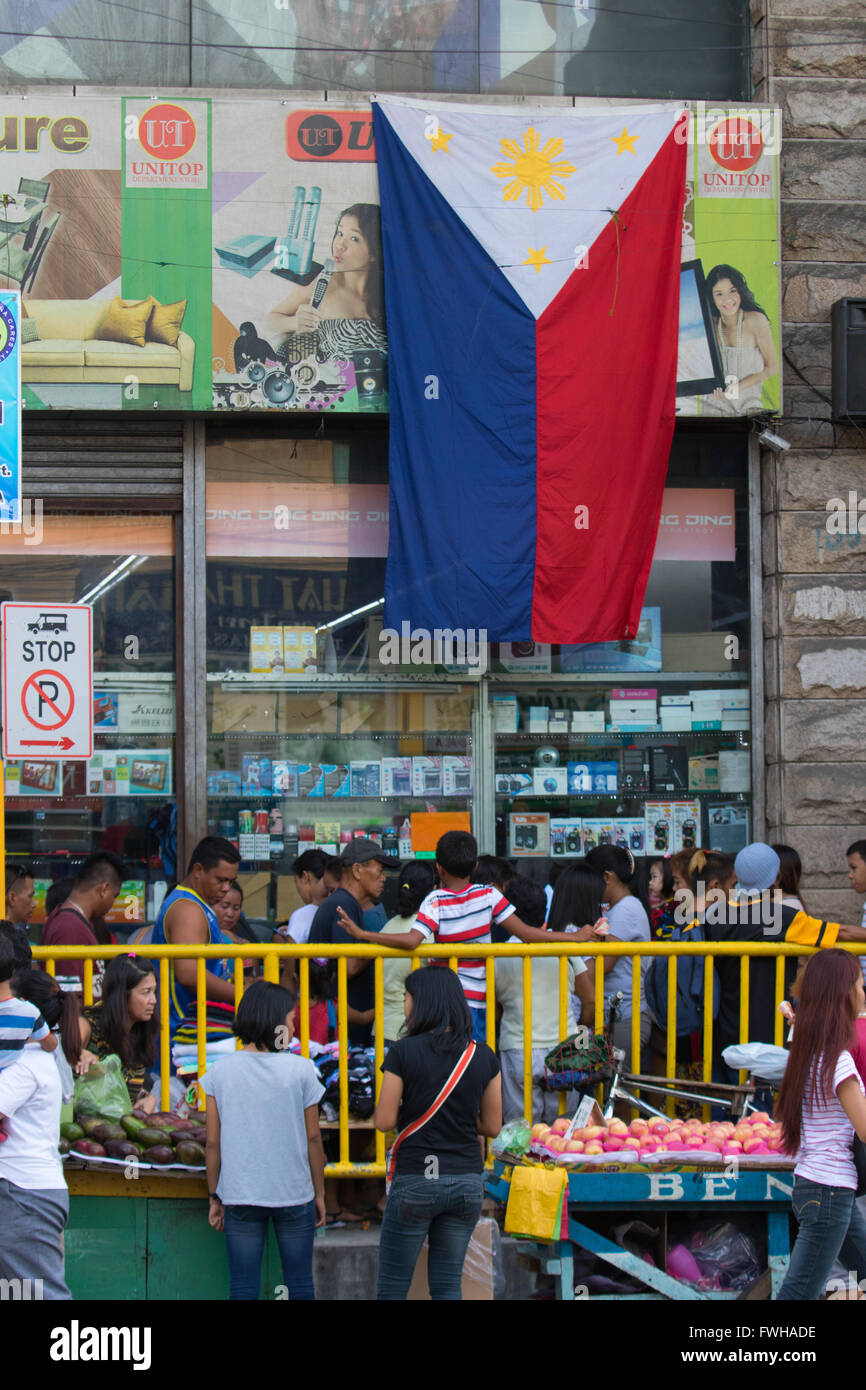 Cebu City, Philippinen. 12. Juni 2016. Einer großen philippinischen Nationalflagge hängt außerhalb Ladengeschäft befindet sich im Zentrum von Cebu City am Tag, den die Nation 118 Jahre nach der Unabhängigkeit von der spanischen Kolonialherrschaft feiert. Bildnachweis: imagegallery2/Alamy Live-Nachrichten Stockfoto