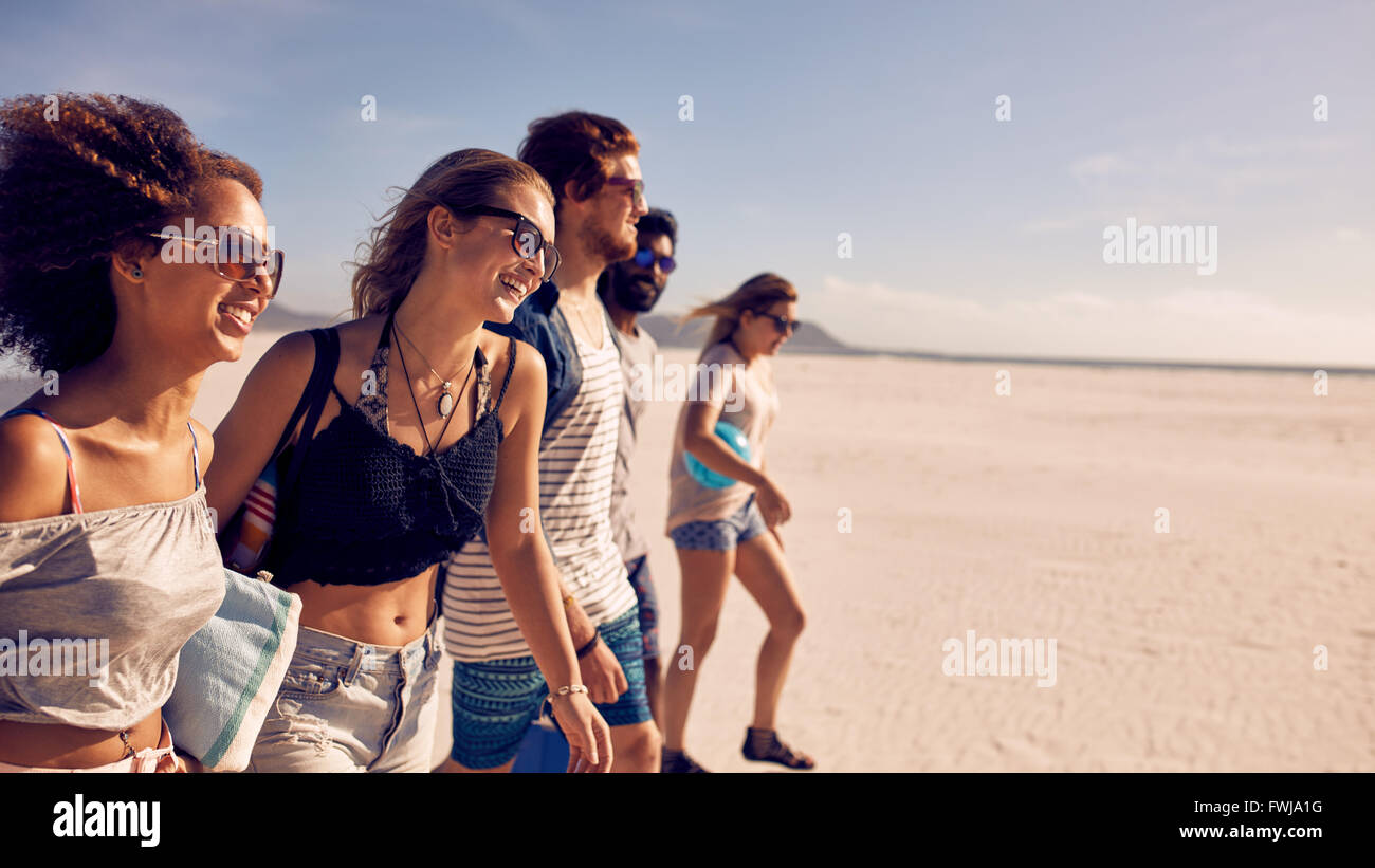 Gruppe von fünf Freunden, die zu Fuß am Strand. Zwei junge Männer und drei junge Frauen im Sommer Strandurlaub. Stockfoto