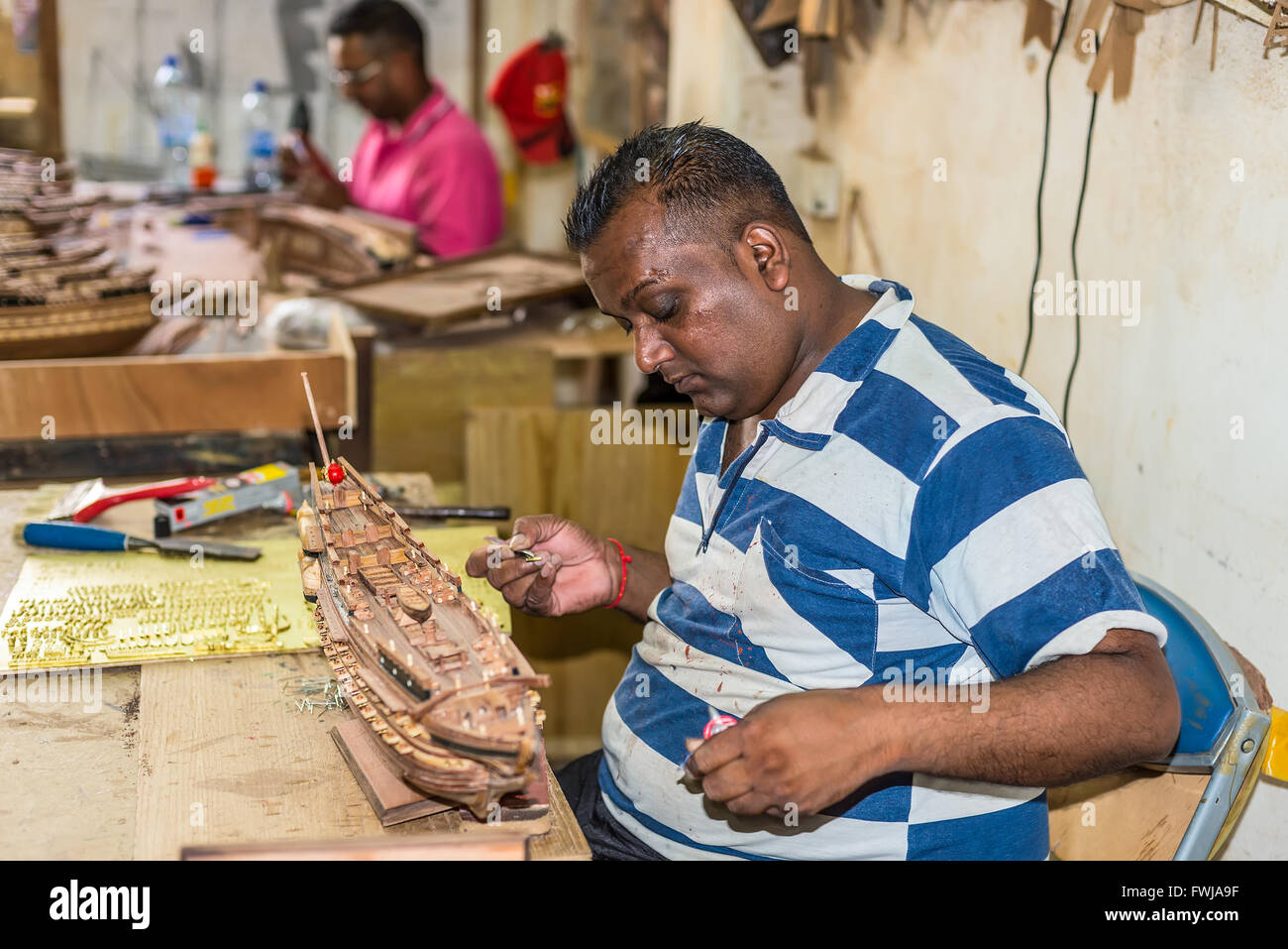 Mann arbeitet auf Holz Segeln Schiffsmodell Le Port Schiff Modelle werkseitig in Floreal, Mauritius Stockfoto