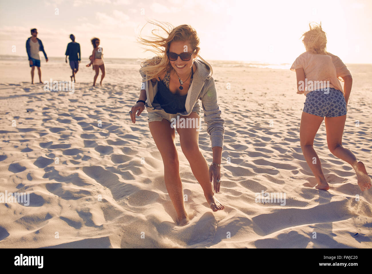 Junge Frauen Rennen am Strand. Gruppe von Jugendlichen, die an einem Sommertag am Sandstrand spielen. Spaß auf der bea Stockfoto