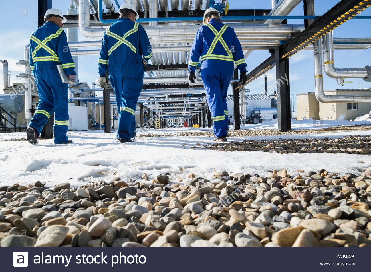 Arbeiter zu Fuß der schneebedeckte Felsen unterhalb der Gasanlage pipeline Stockfoto
