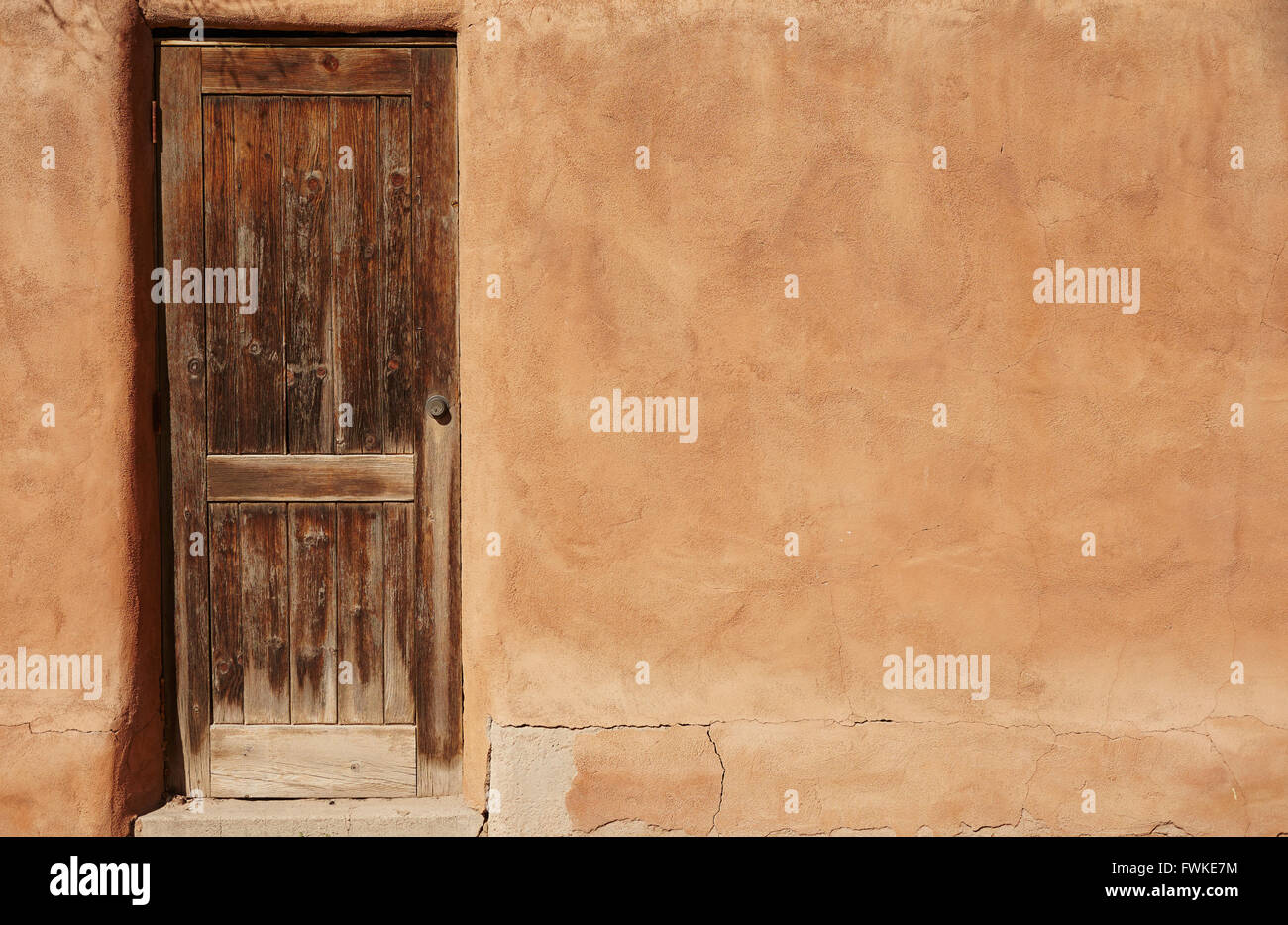 Adobe-Wand und Holztür, Los Cerrillos, New Mexico, USA Stockfoto