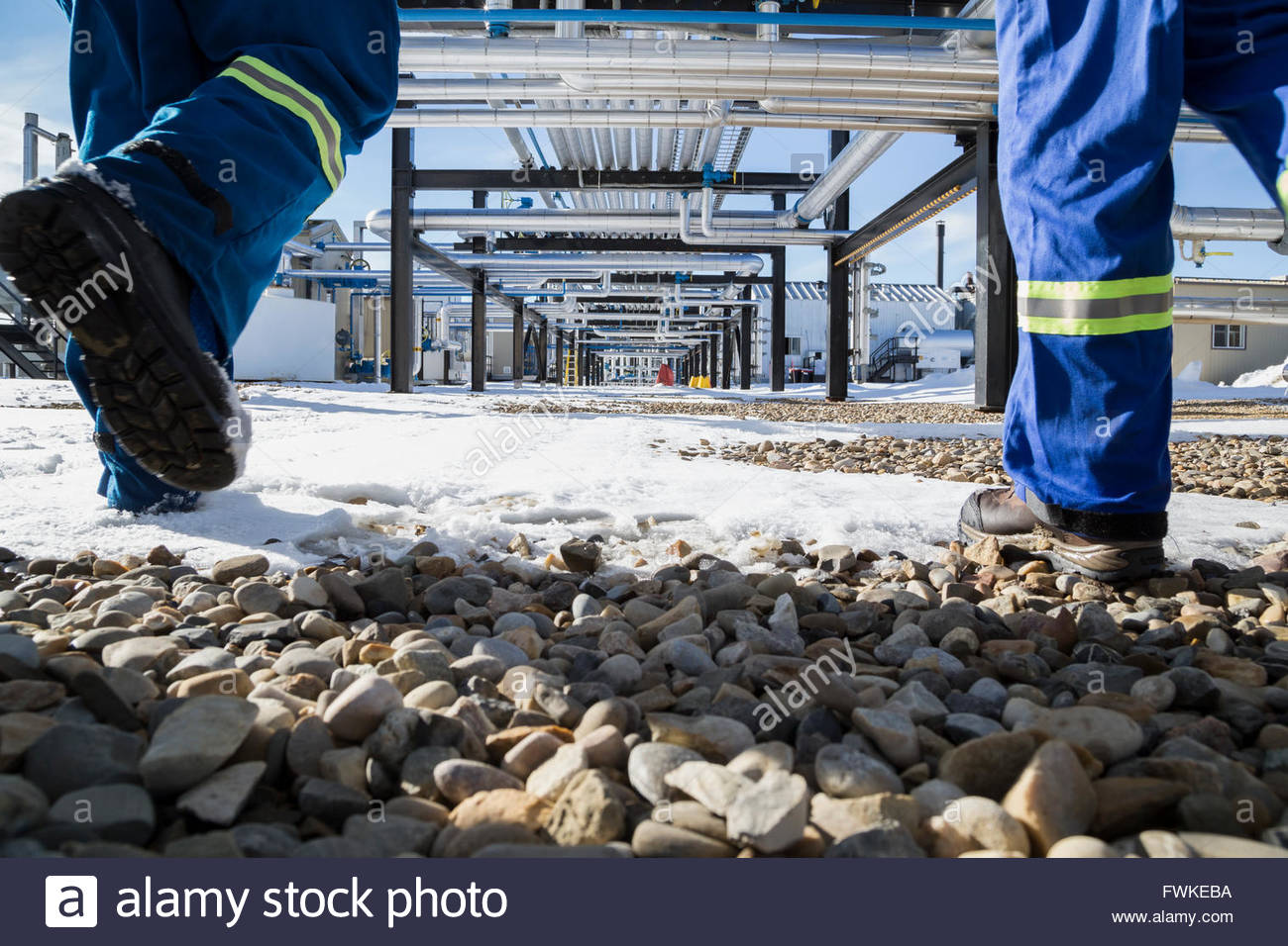 Arbeiter zu Fuß der schneebedeckte Felsen unterhalb der Gasanlage pipeline Stockfoto