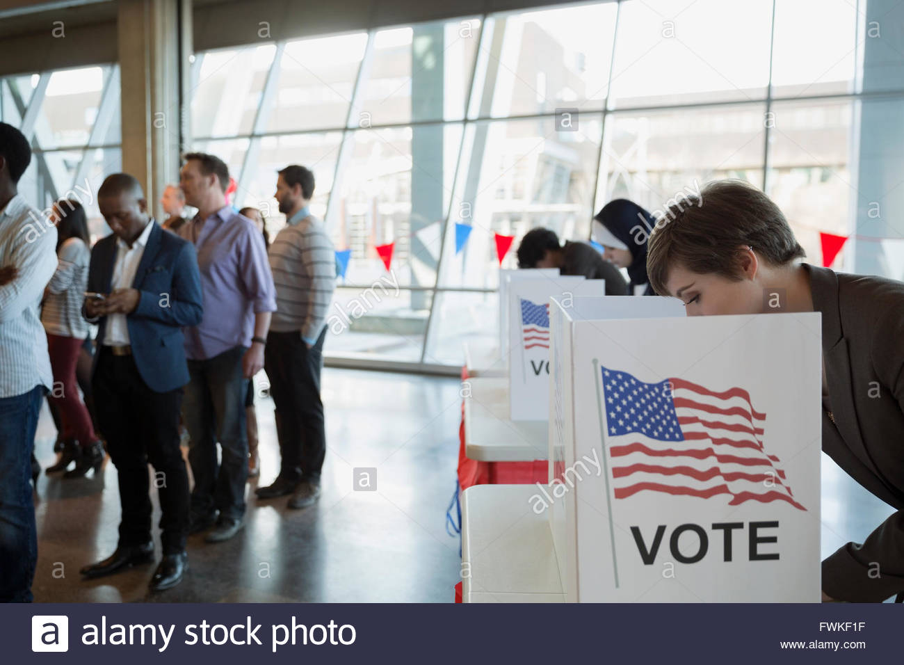 Junge Frau bei der Abstimmung stand im Wahllokal Stockfoto