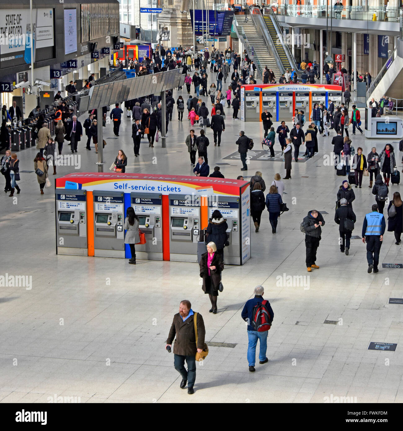 Ansicht von oben nach unten auf Pendler auf London Waterloo Bahnhofshalle mit zwei Reihen von Self-Service-Automaten England UK Stockfoto