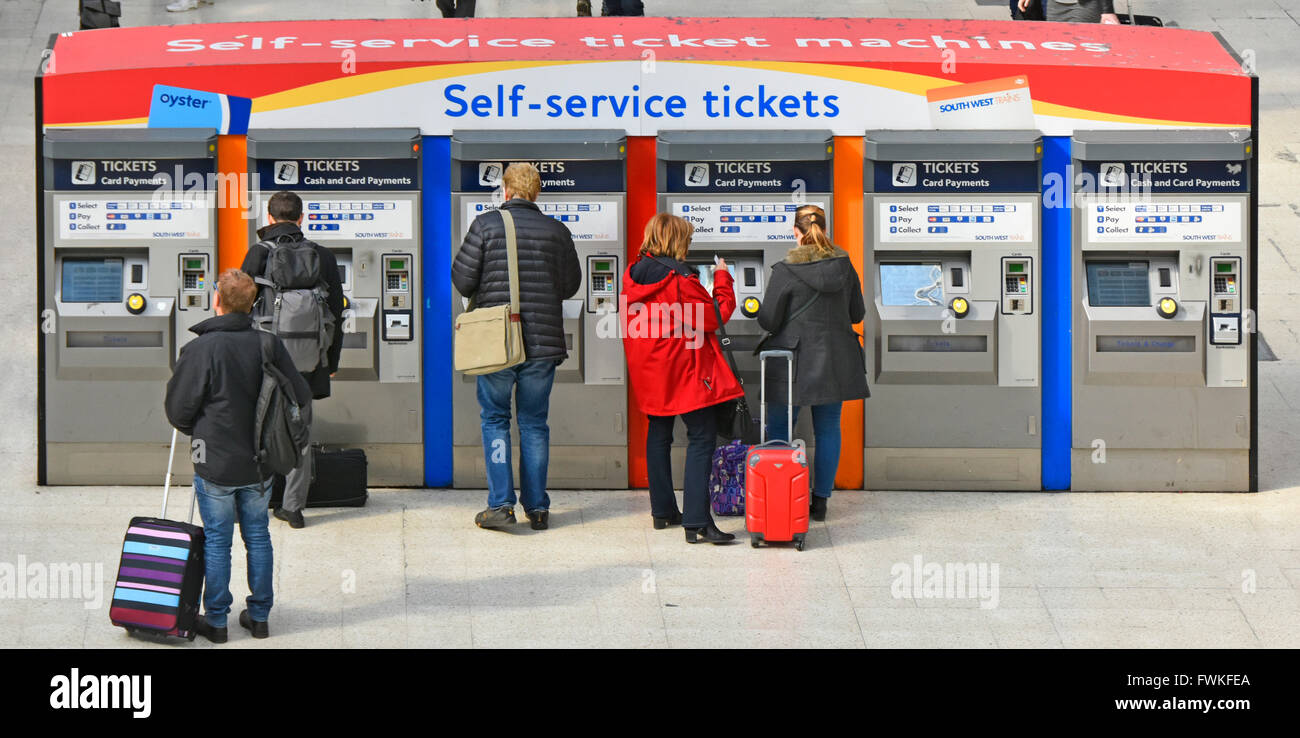 Self-Service-Tickets Rückansicht Zugpassagiere und Gepäck mit Wartezeiten an Automaten Haupthalle London Waterloo Hauptbahnhof England Großbritannien Stockfoto