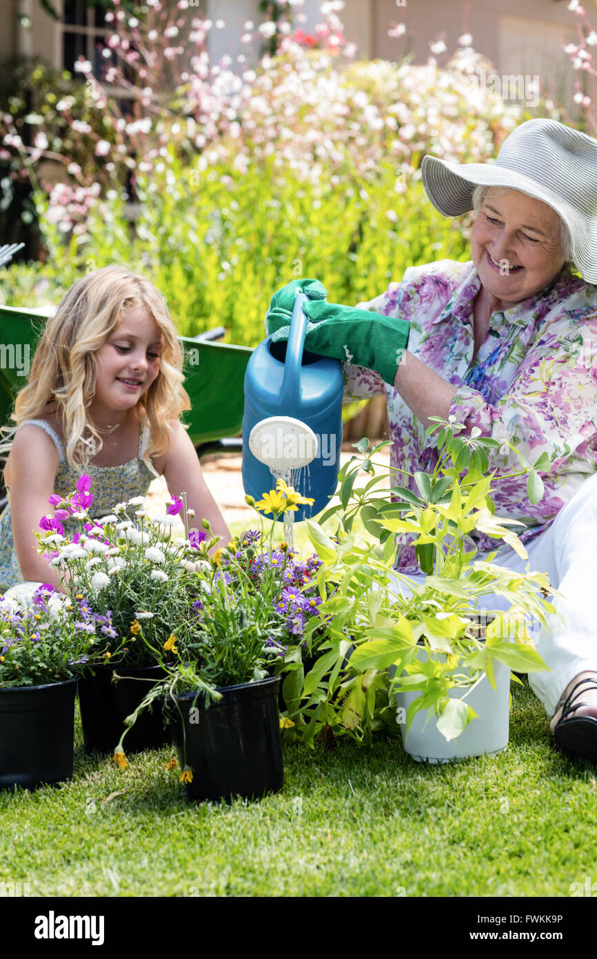 Großmutter und Enkelin, die Bewässerung der Pflanzen im Garten Stockfoto