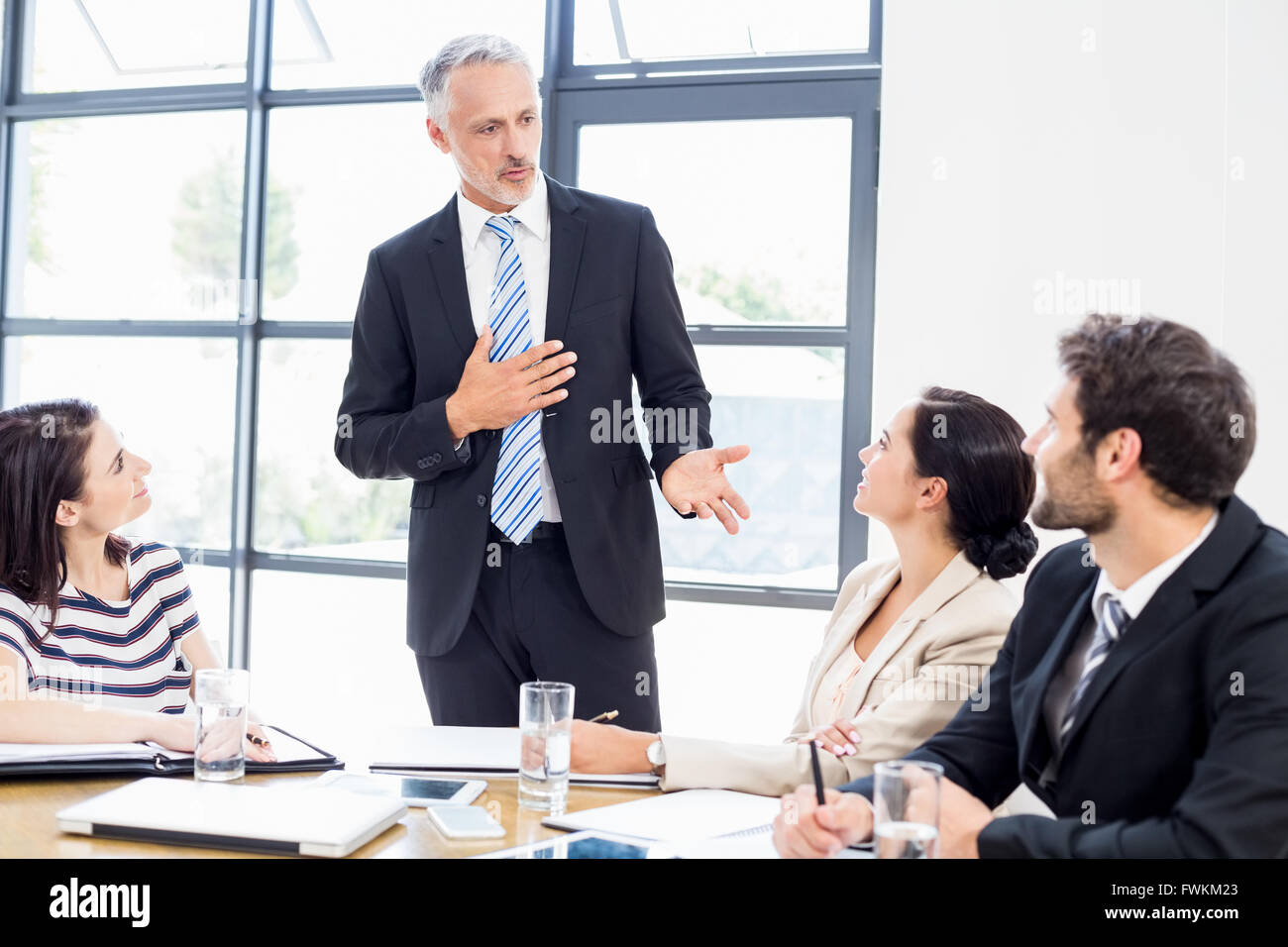 Ein Geschäftsmann steht vor seinen Kollegen und sprechen Stockfoto