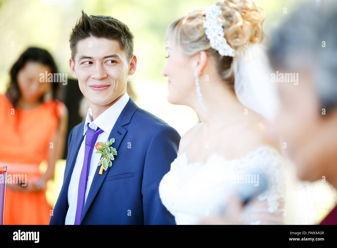 Glückliche Bräutigam schaut Braut während der Trauung. Stockfoto