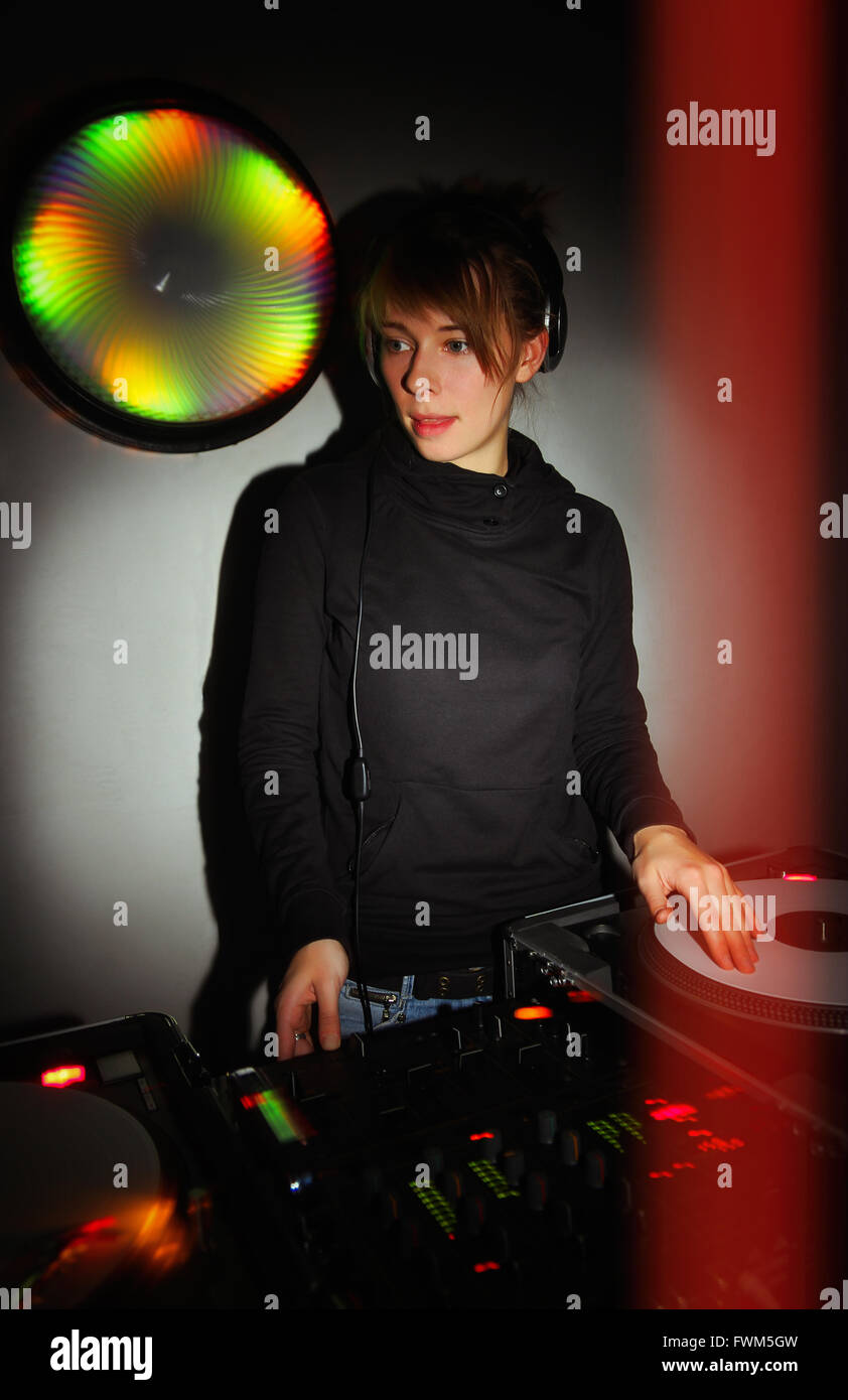 Junge weibliche DJ Musik auf professionelle Turntables und vier-Kanal-sound-Mixer im dunklen Sound recording Studio oder Nachtclub Stockfoto