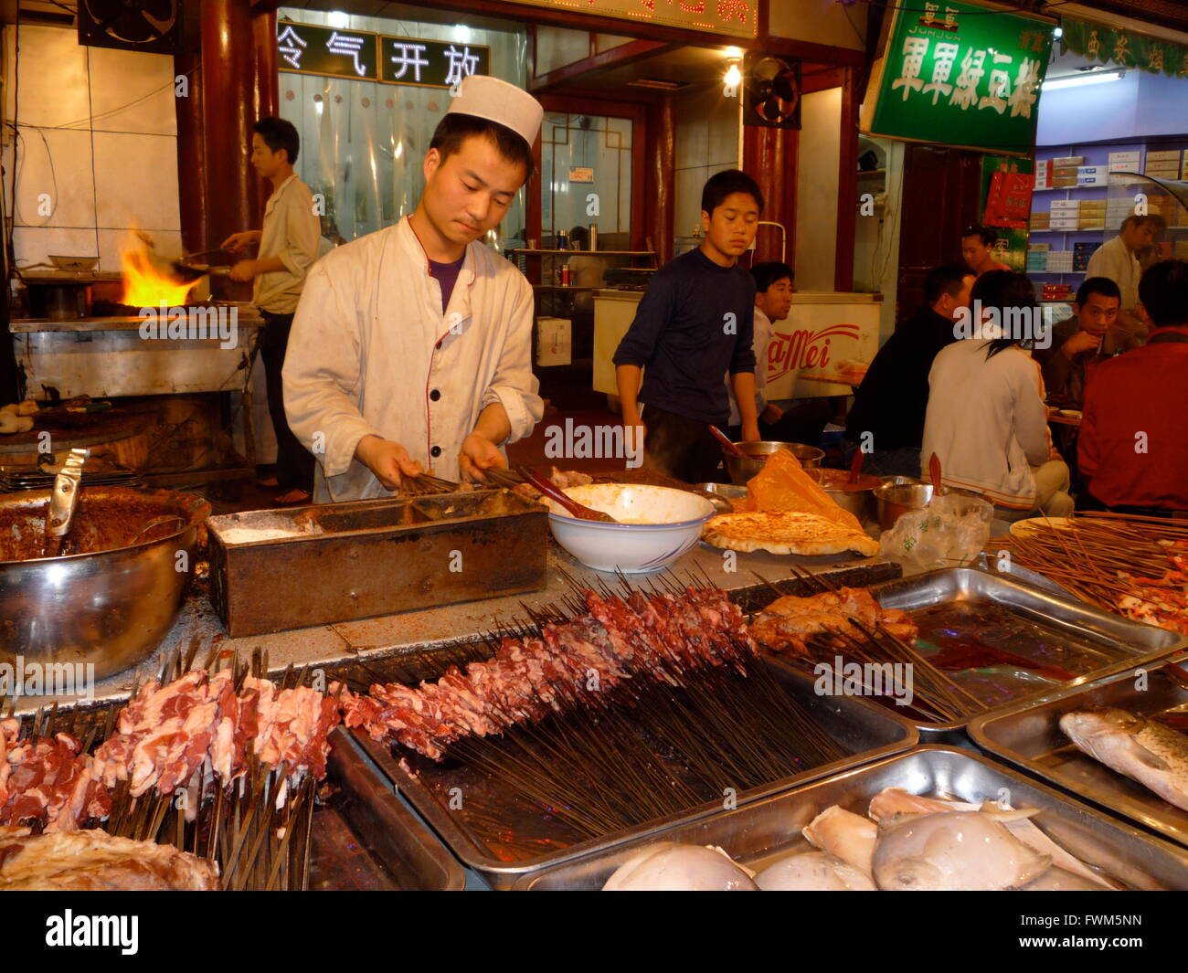 Mann bereitet Spieße auf einem Streetfood-Markt in Xi ' an, Shaanxi, China Stockfoto