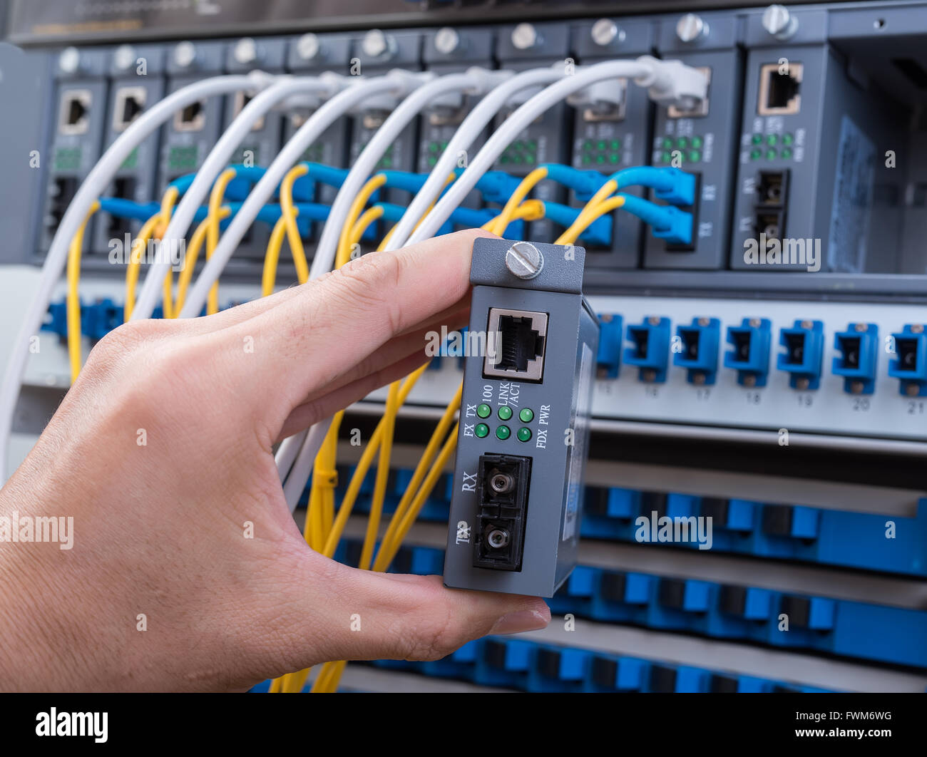 Mann bei der Arbeit im Netzwerk Server Zimmer mit LWL-Hub für die digitale Kommunikation und Internet Stockfoto