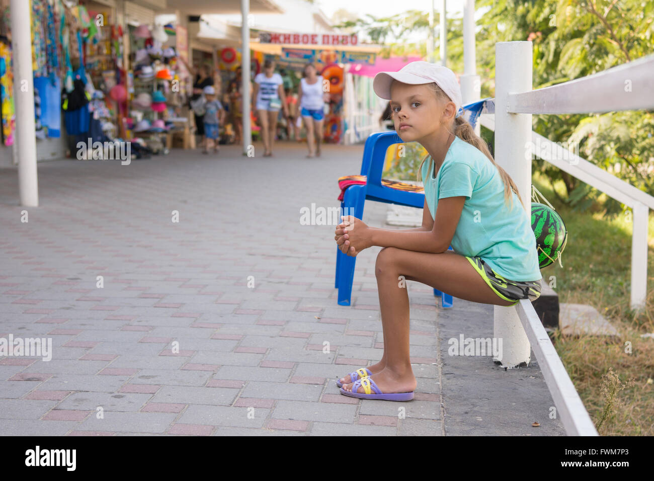 Müde Mädchen sitzt etwa sechs Jahren Handel Pavillons mit Sommerartikel Stockfoto