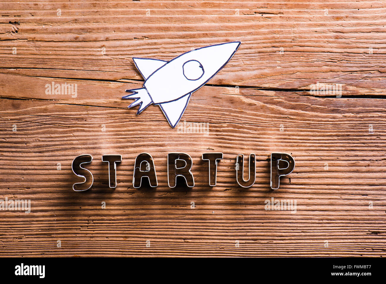 Schreibtisch mit Start-up-Zeichen und Papier-Rakete. Stockfoto
