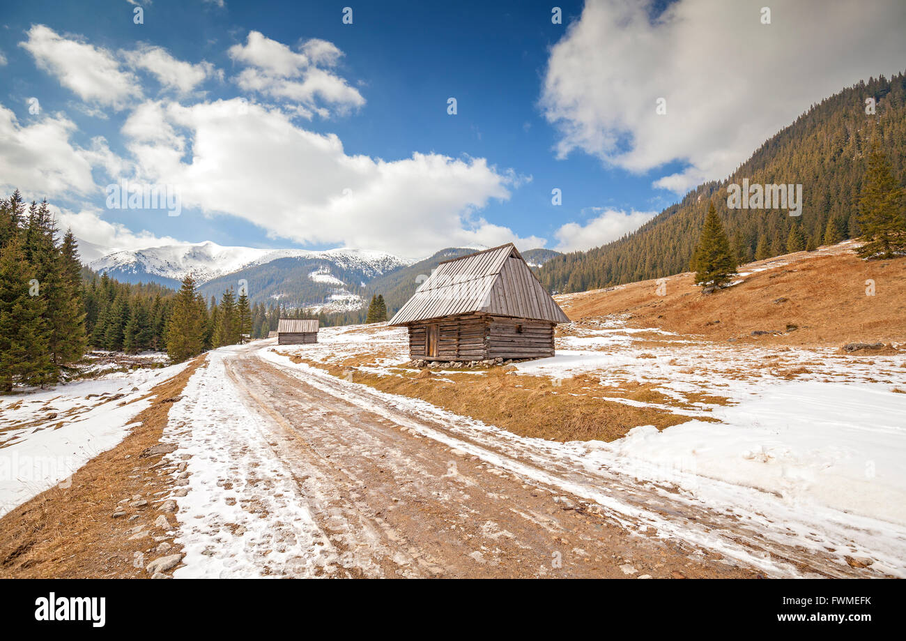 Holzhütten von einem Feldweg in Tatra-Gebirge, Ende des Winters und Frühlingsbeginn, Polen. Stockfoto