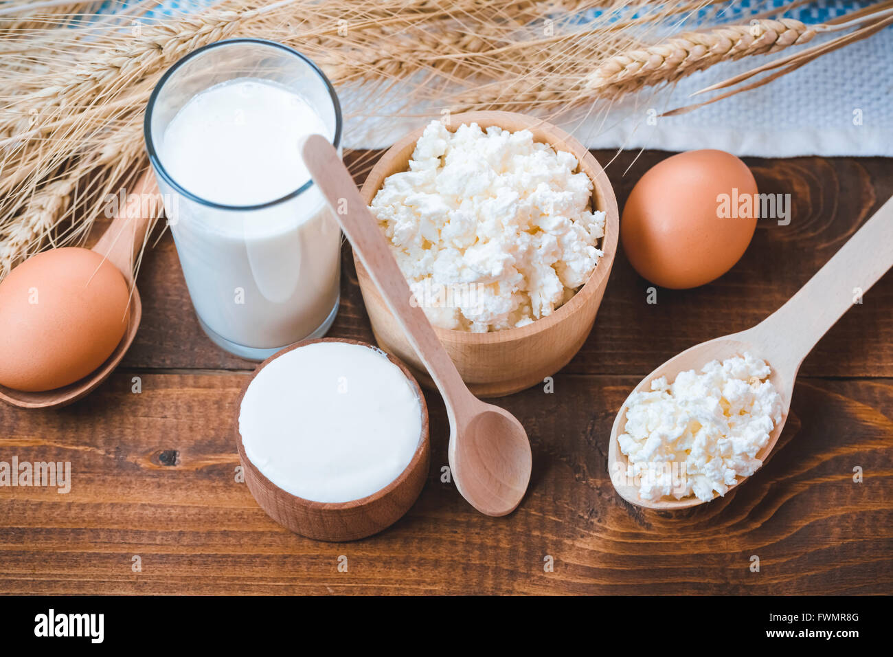 Natürliche selbstgemachte Produkte: Milch, Käse, Sauerrahm und Eiern auf den alten hölzernen Hintergrund mit Ähren. mit Platz für Ihre te Stockfoto