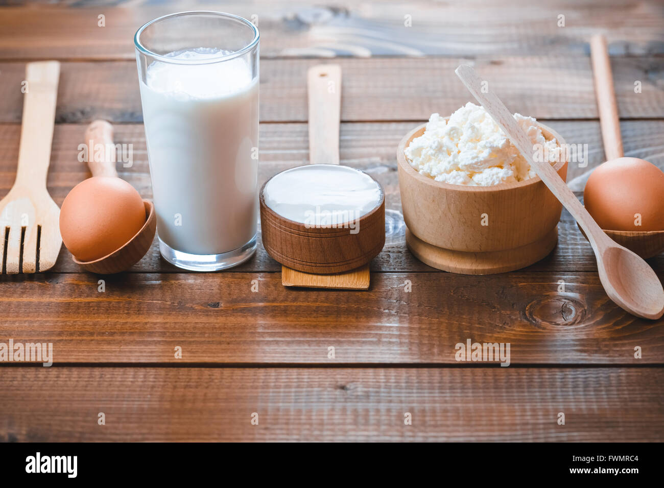 Milchprodukte auf Holztisch. Saure Sahne, Milch, Käse, Joghurt und Eier. Ansicht von oben mit der Kopie Raum Stockfoto