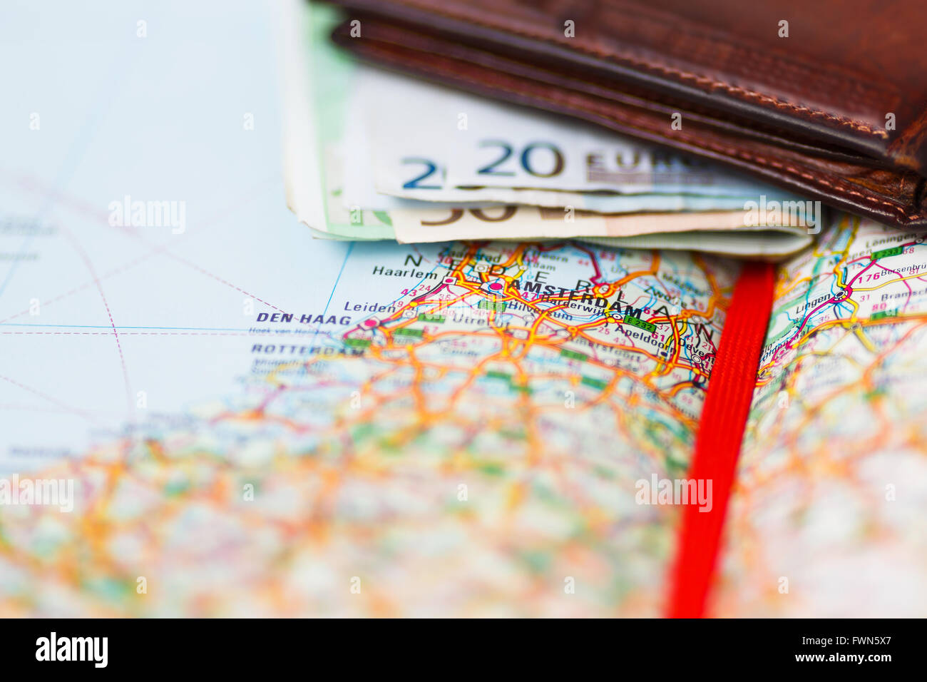 Euro-Banknoten im Portemonnaie auf einer geografischen Karte von Amsterdam, Niederlande Stockfoto